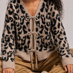 Close-up of the leopard print knit cardigan showing the V-neckline and front bow ties