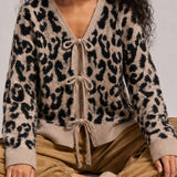Close-up of the leopard print knit cardigan showing the V-neckline and front bow ties