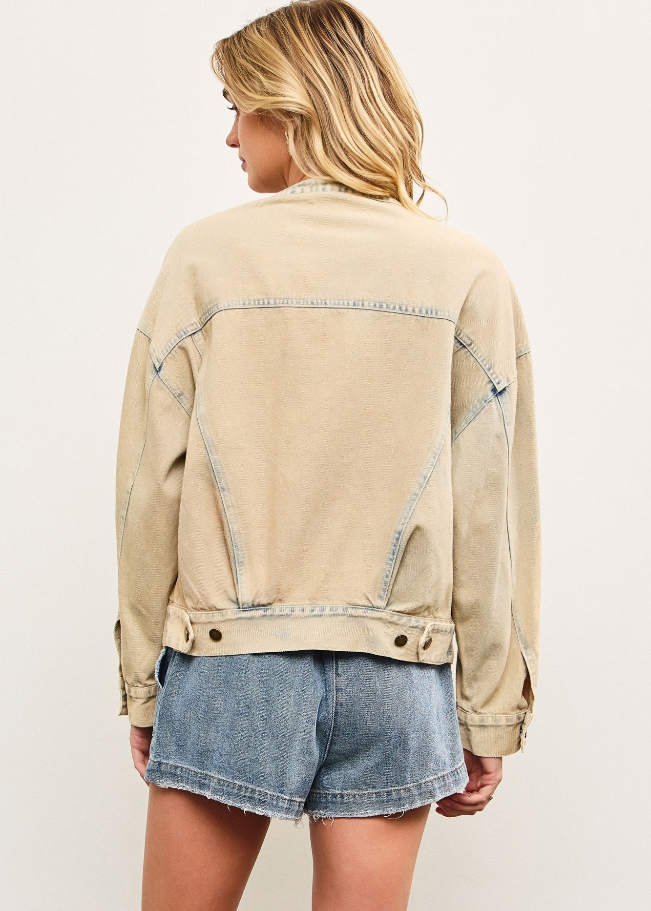 Back view of light wash casual denim jacket with relaxed bomber shape
