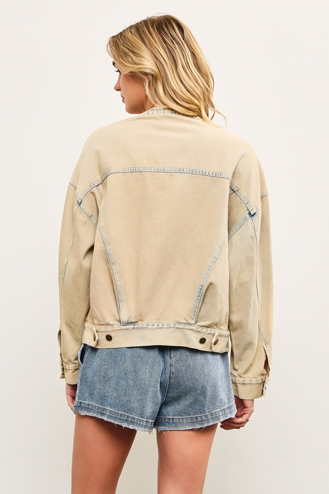 Back view of light wash casual denim jacket with relaxed bomber shape
