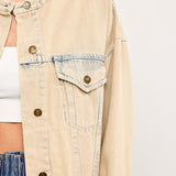 Close-up of banded collar and chest pockets on light wash denim jacket in sand denim