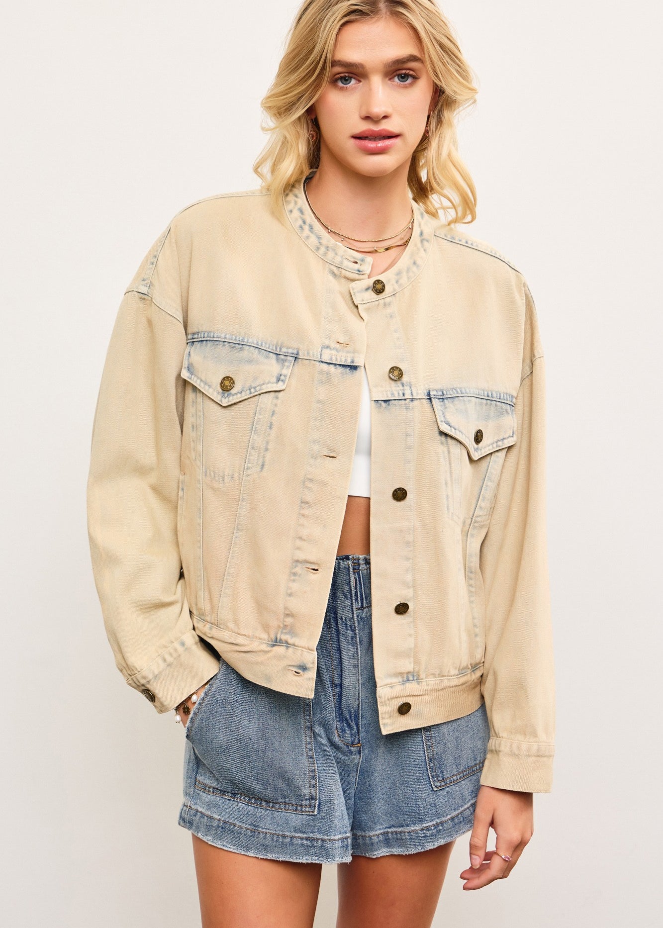 Light wash casual denim jacket in sand denim with cropped boxy fit (bomber fit jacket) on a model