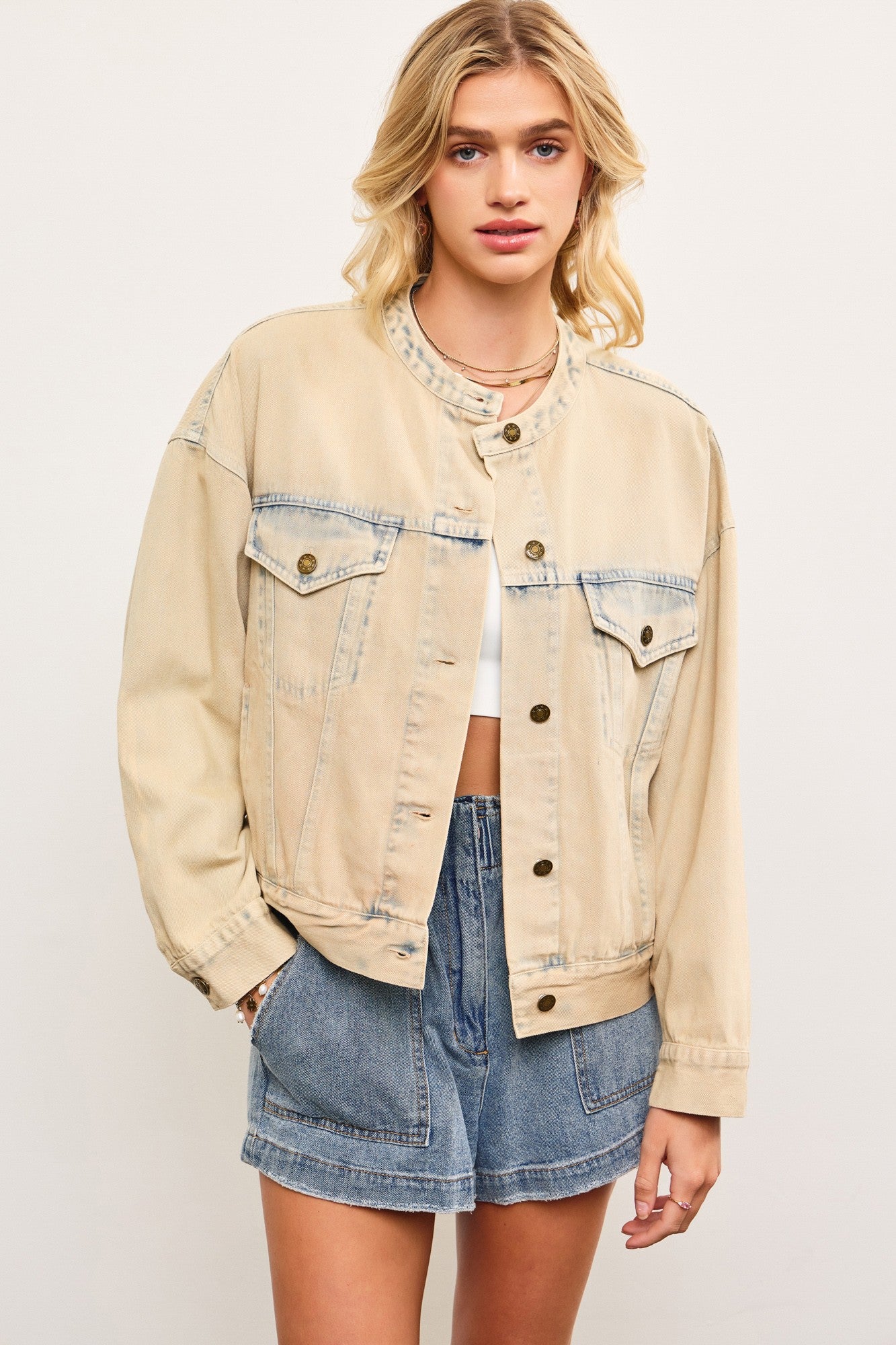 Light wash casual denim jacket in sand denim with cropped boxy fit (bomber fit jacket) on a model