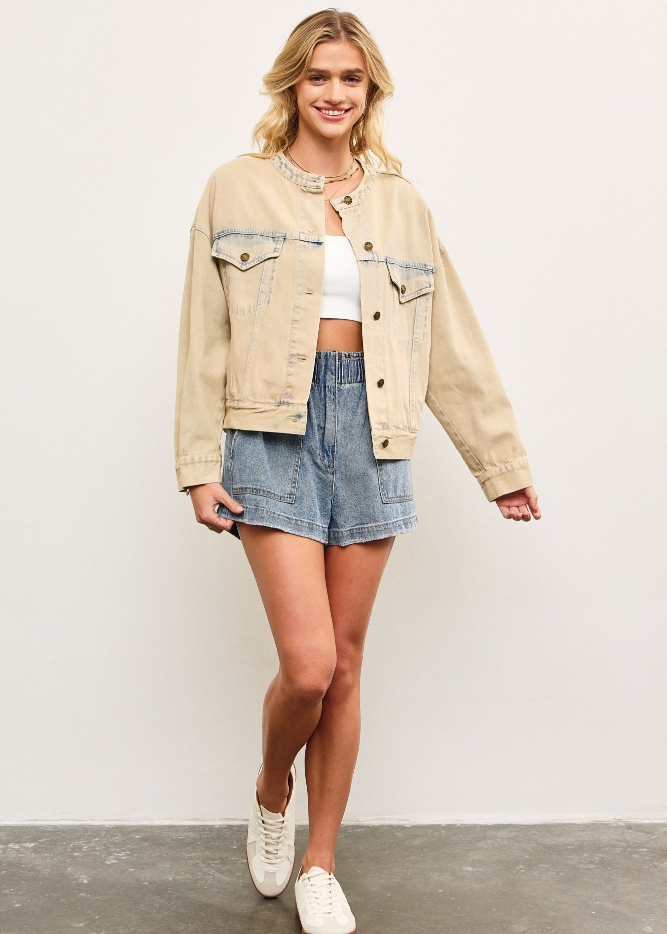 Full body view of light wash casual denim jacket styled with skirt