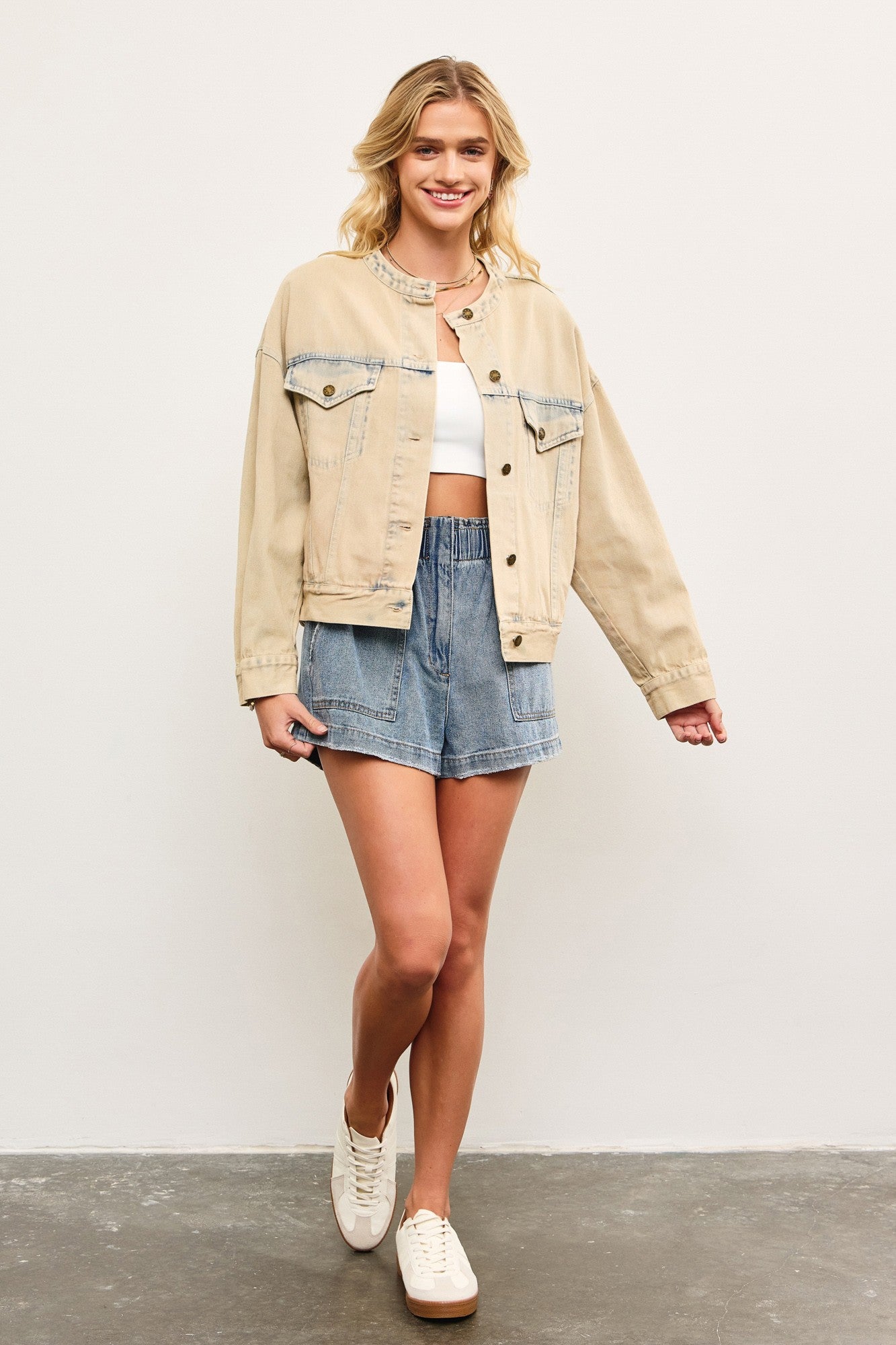Full body view of light wash casual denim jacket styled with skirt