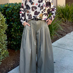 Full-body view of the batwing printed sweater styled with wide-leg pants