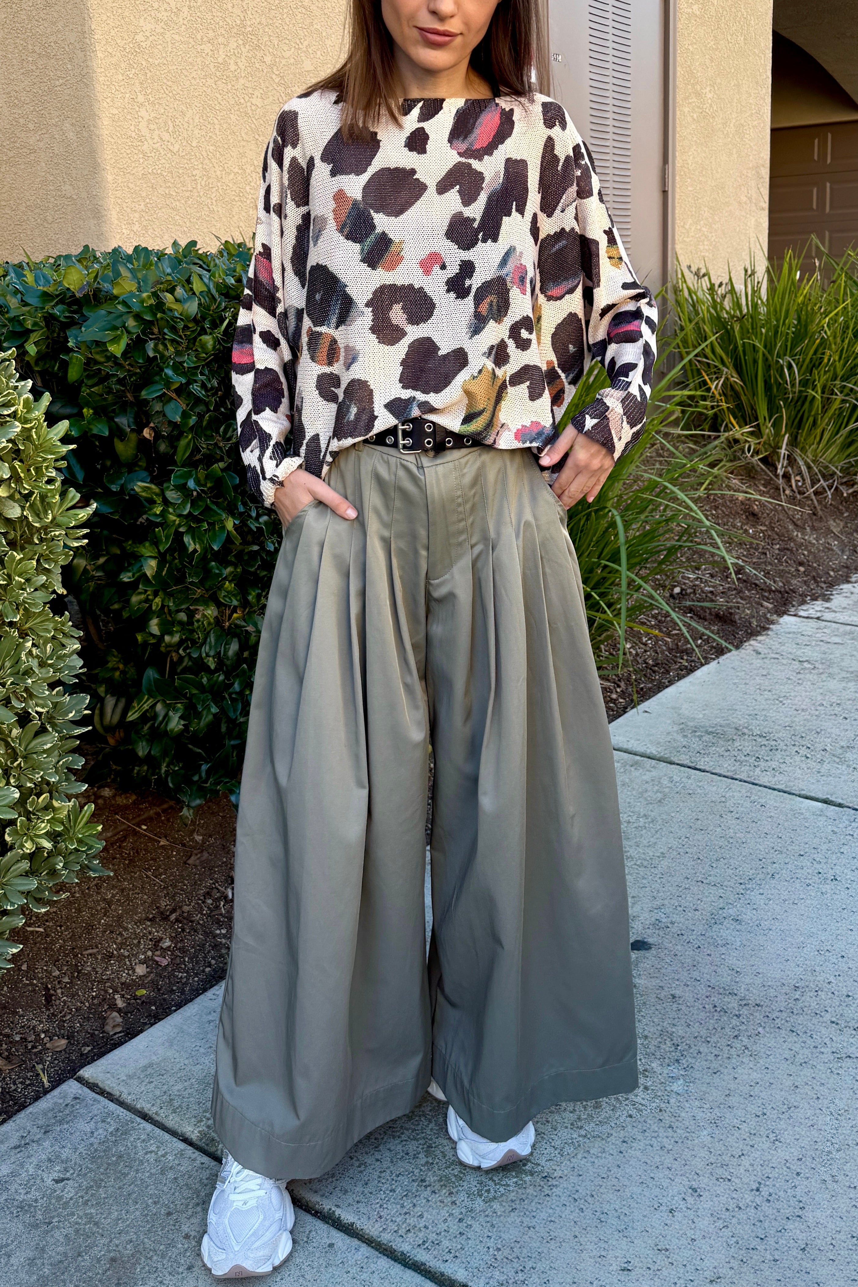 Full-body view of the batwing printed sweater styled with wide-leg pants