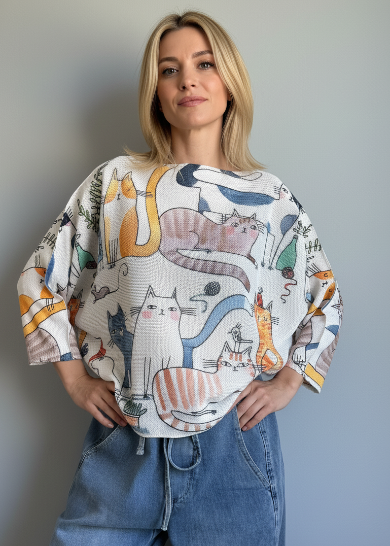 Front portrait of model wearing the Livia Made in Italy batwing printed sweater with playful cats print