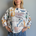 Front portrait of model wearing the Livia Made in Italy batwing printed sweater with playful cats print