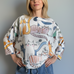 Front portrait of model wearing the Livia Made in Italy batwing printed sweater with playful cats print