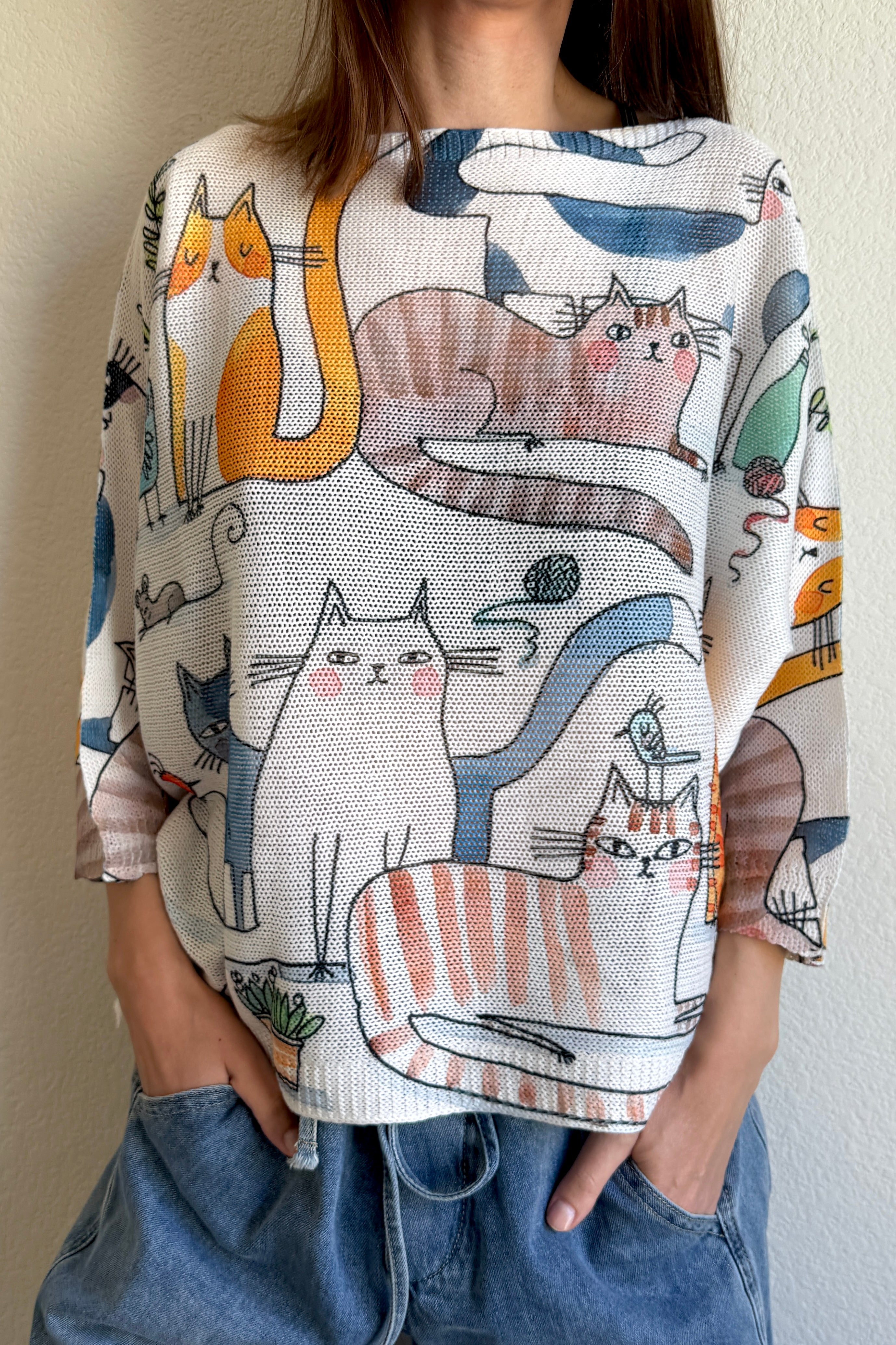 Styled front view of the Livia Made in Italy batwing printed sweater paired with jeans