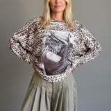 Front portrait of model wearing the Livia Made in Italy batwing printed sweater with cowgirl print