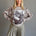 Front portrait of model wearing the Livia Made in Italy batwing printed sweater with cowgirl print