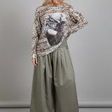 Full-body view of the batwing cowgirl print sweater styled with wide-leg pants