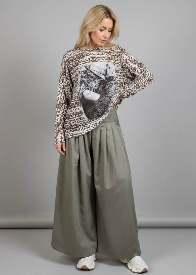 Full-body view of the batwing cowgirl print sweater styled with wide-leg pants