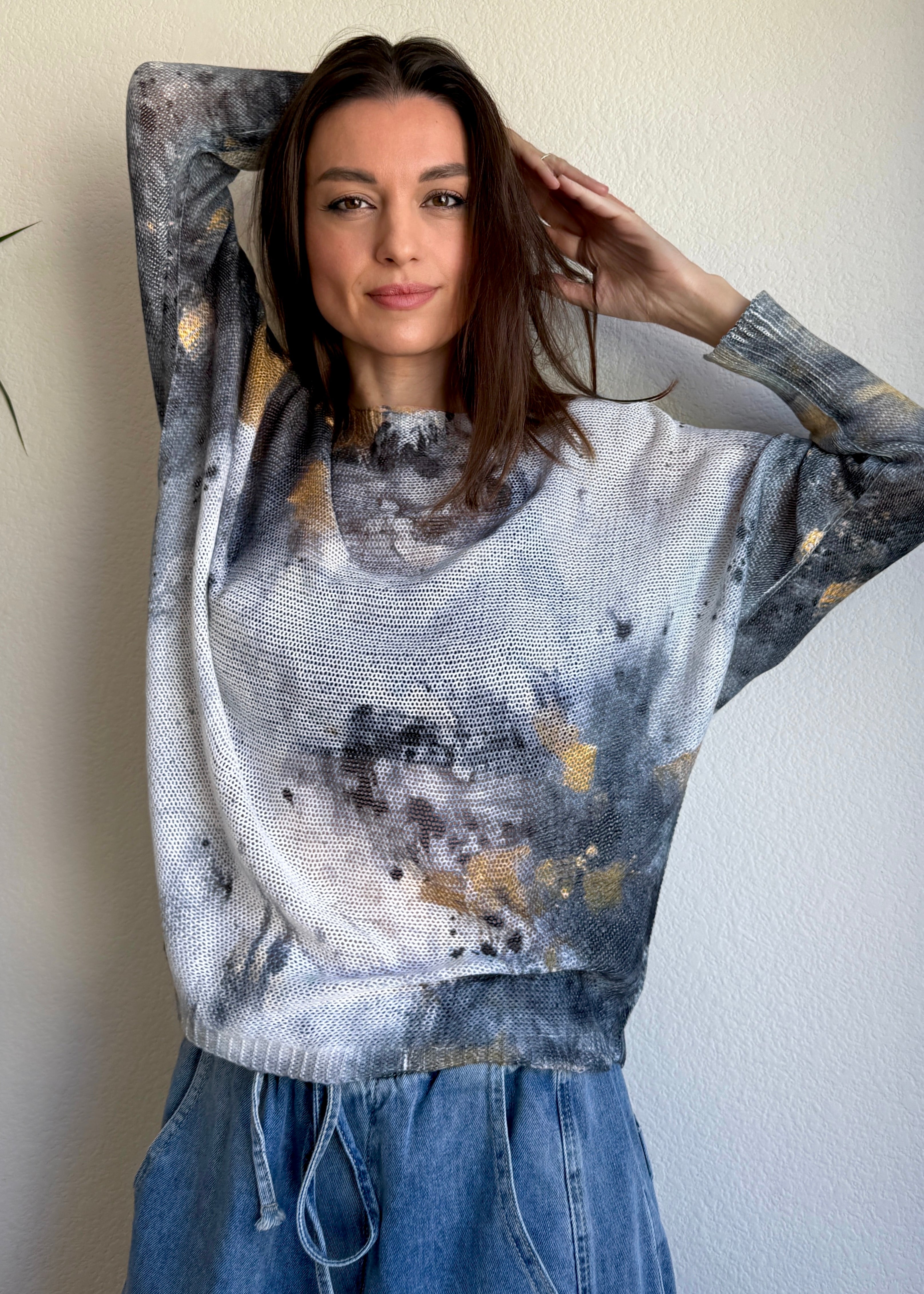 Styled front view of the Livia batwing printed sweater paired with jeans