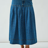 Front walking view of the Lotus Basque Denim Midi Skirt showing movement