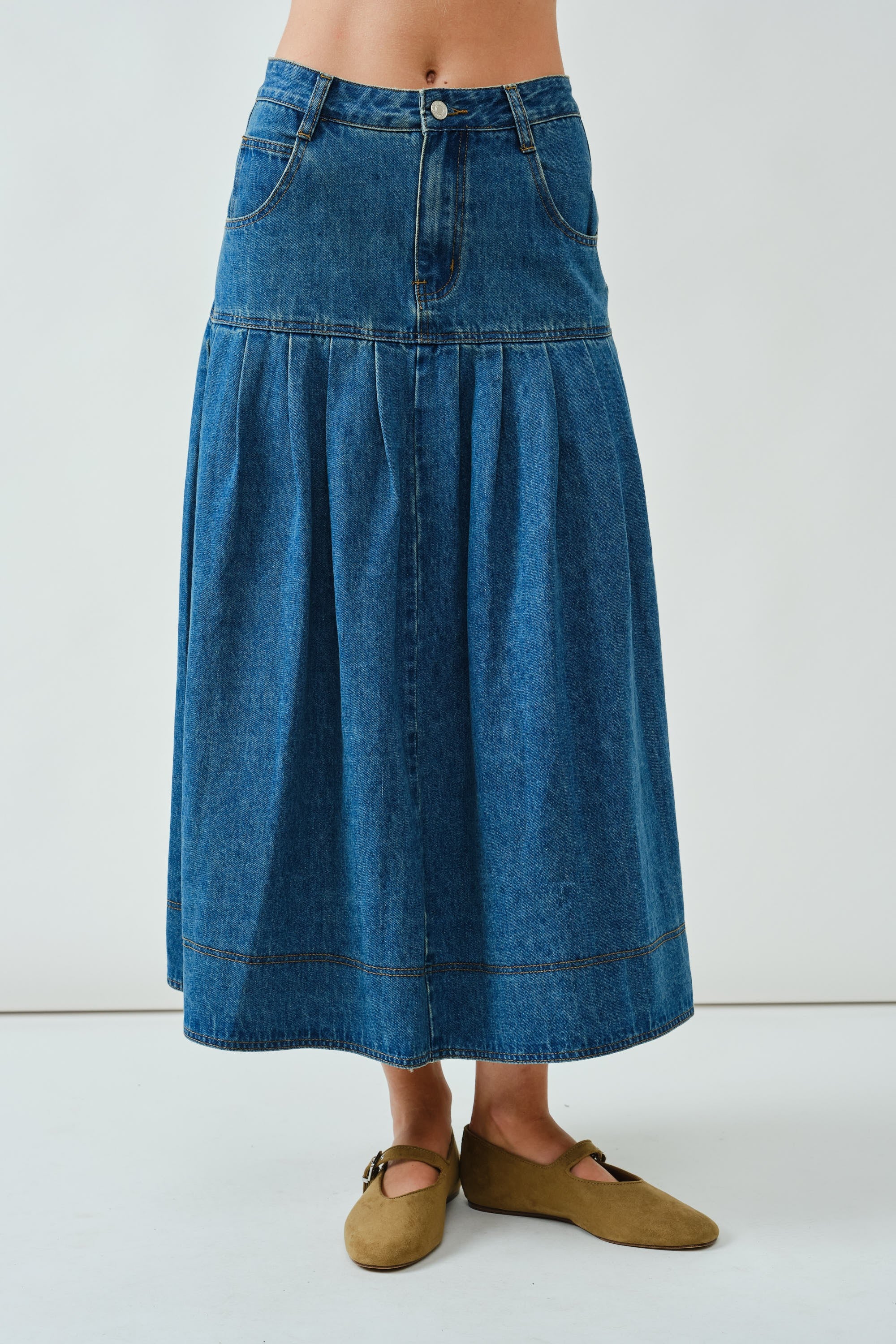 Front walking view of the Lotus Basque Denim Midi Skirt showing movement