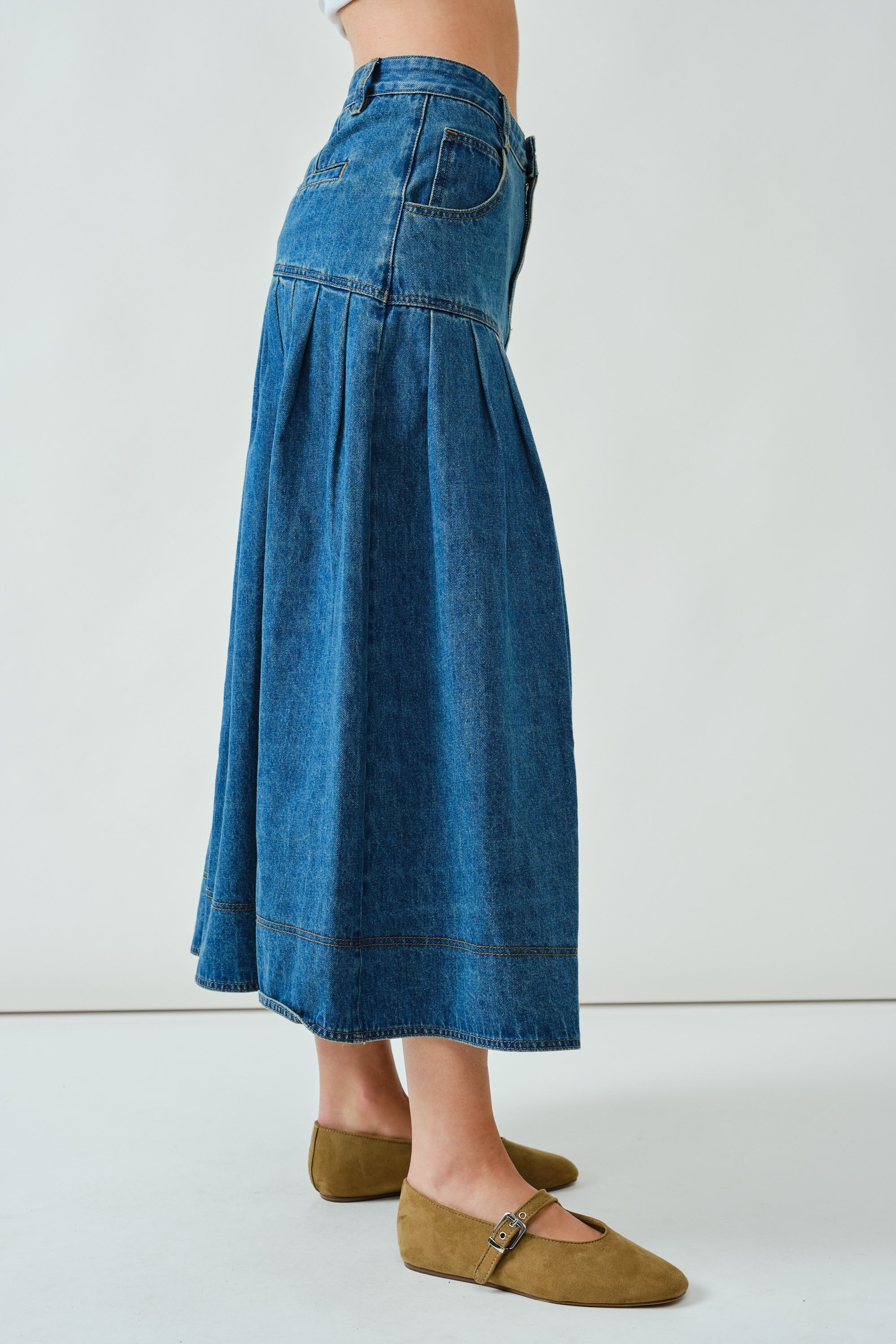 Side walking view of the denim midi skirt showing drape and volume