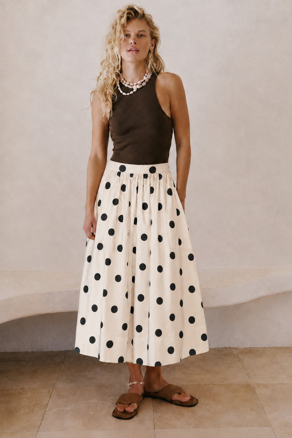 Lowen Full Midi Skirt in Polka Dot Cream styled with a dark sleeveless top and sandals for an effortless everyday outfit