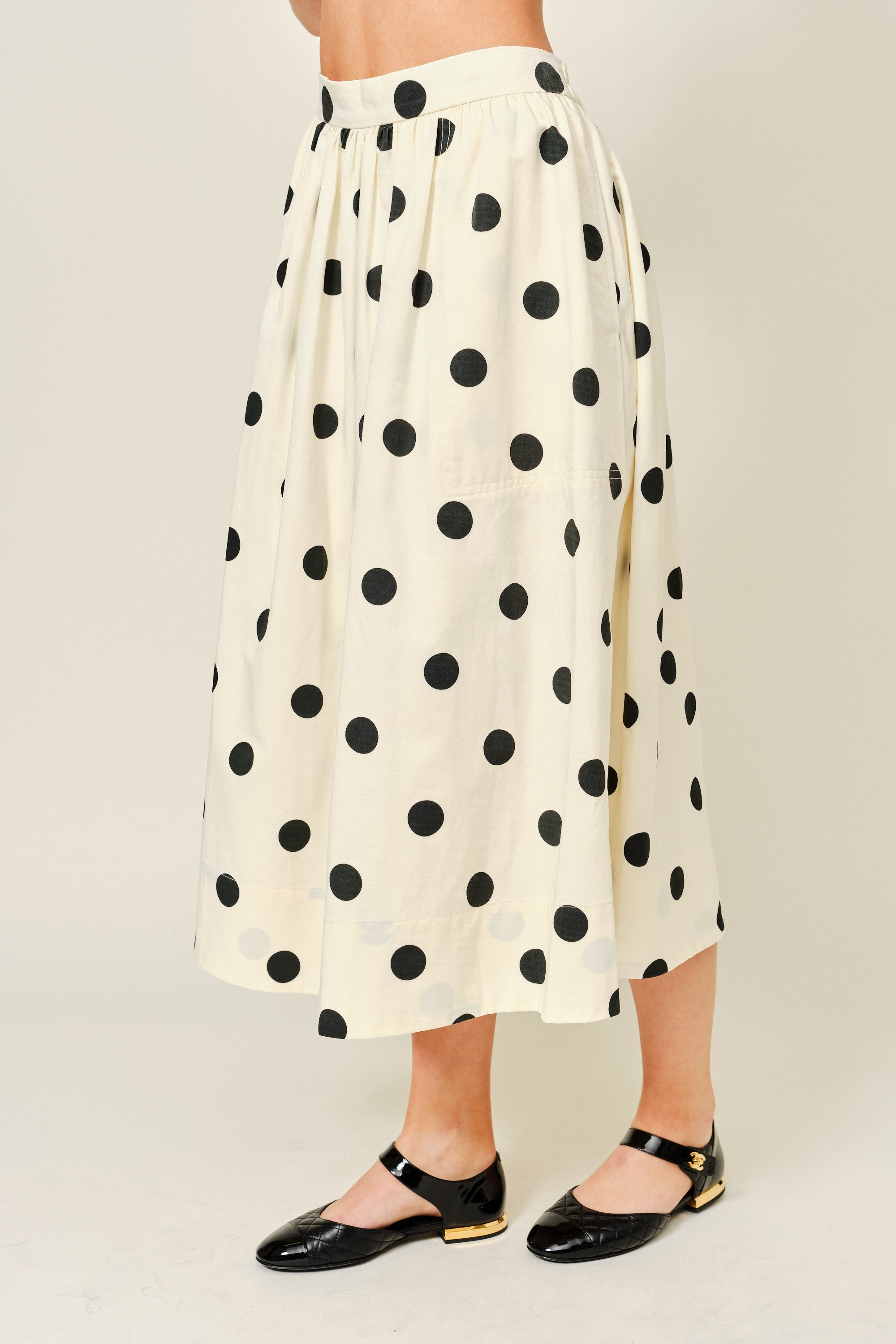 Side view of Lowen Full Midi Skirt in Polka Dot Cream showing the full midi length, soft volume, and side pocket detail