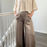 Person wearing Luna Satin Wide Leg Pants in Olive 