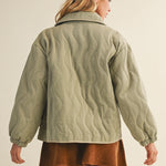 Back view of the olive quilted cotton jacket showing relaxed silhouette