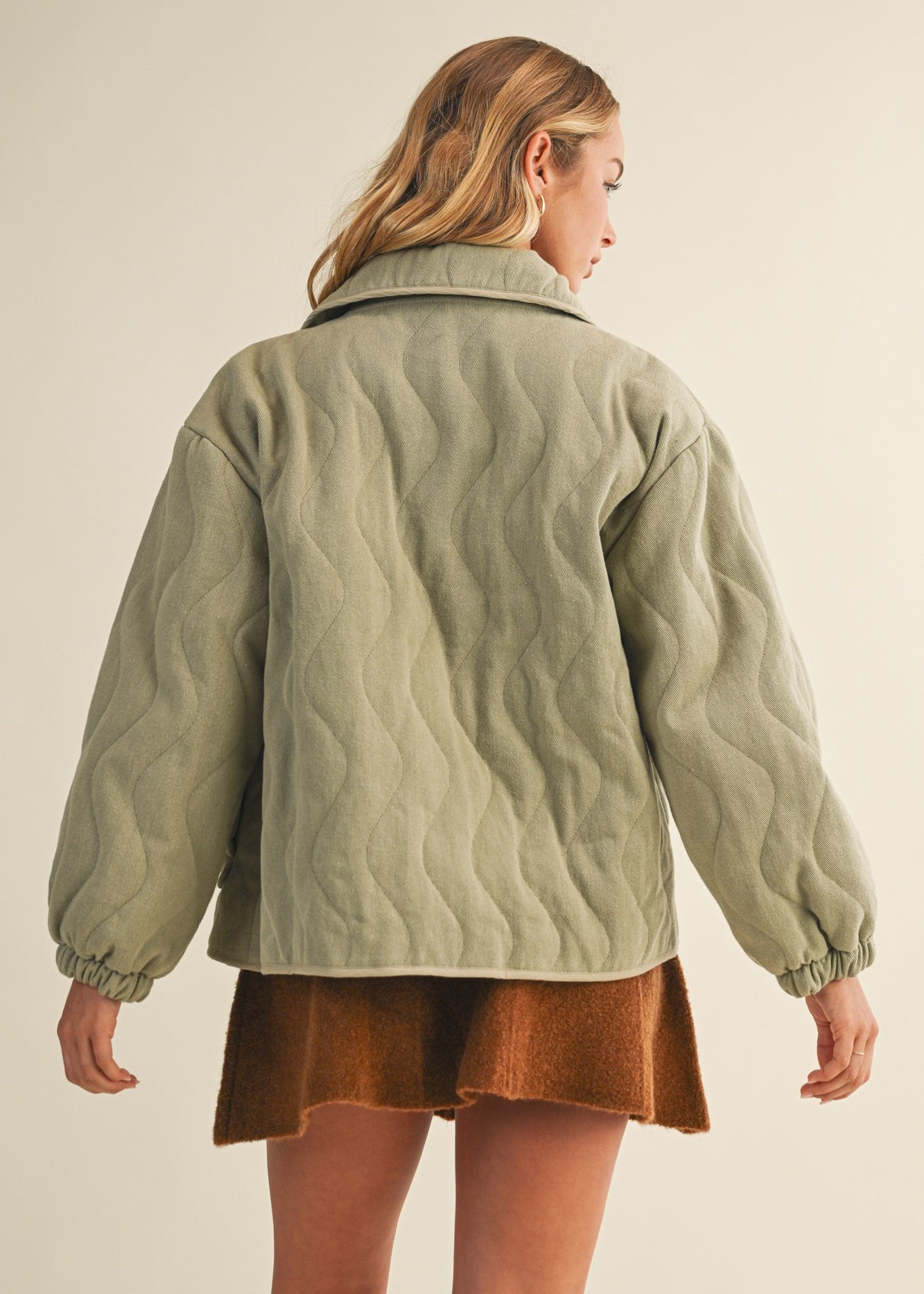Back view of the olive quilted cotton jacket showing relaxed silhouette