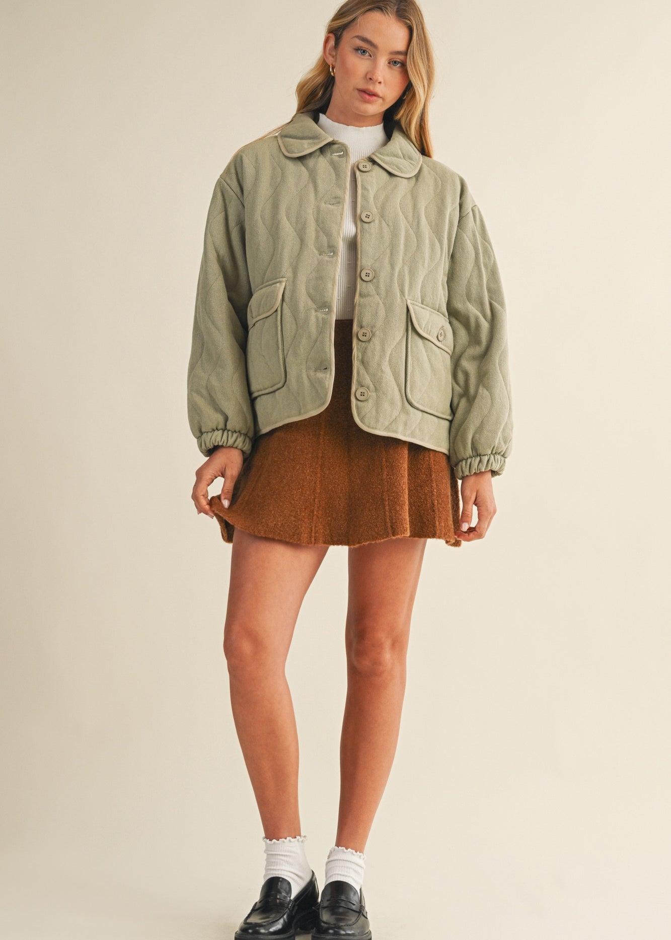 Full-body front view of the Magnolia Wave Quilted Cotton Jacket in olive styled with a skirt