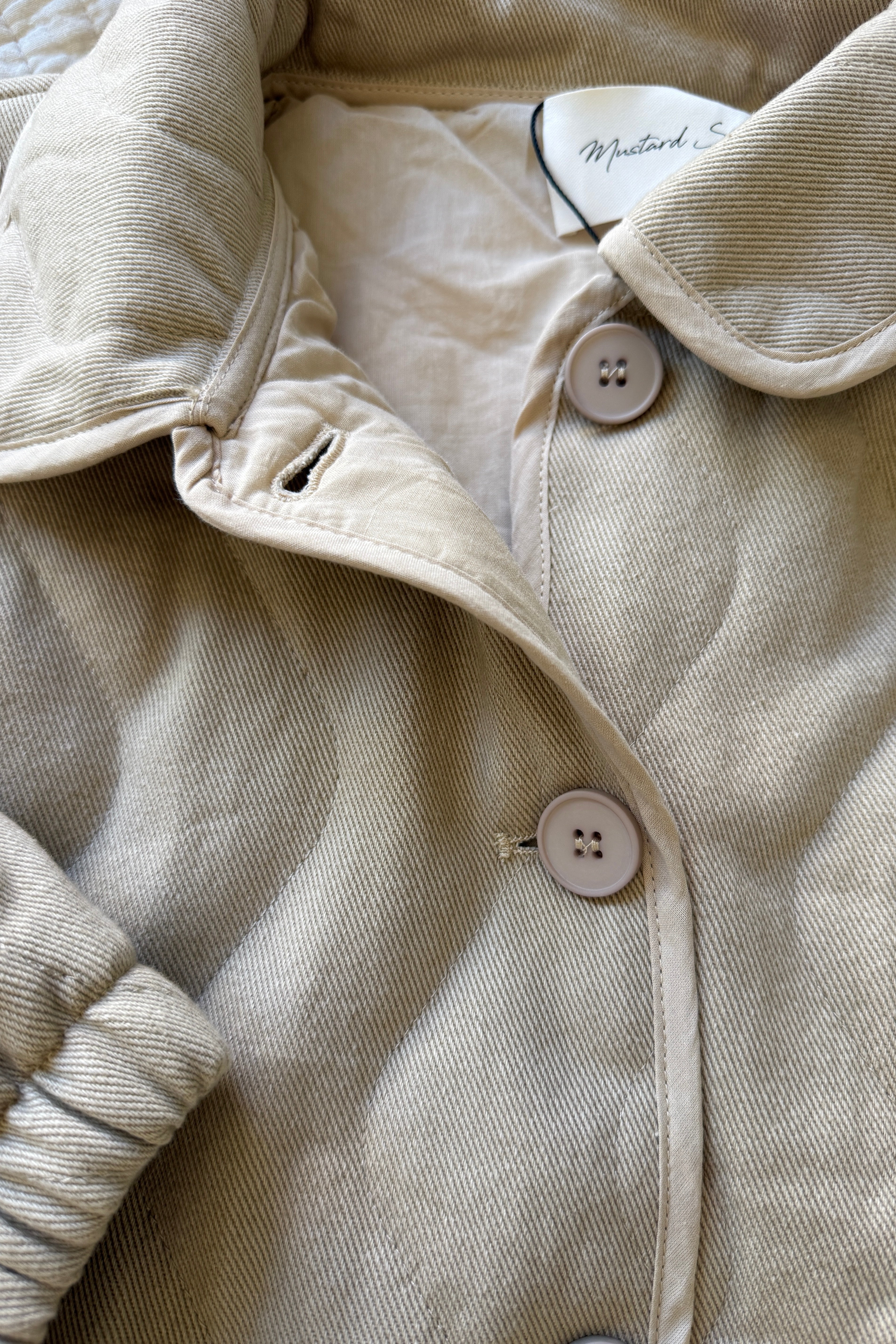 Close-up detail of pocket and stitching on the wheat quilted cotton jacket
