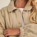 Close-up front detail of the wheat quilted cotton jacket showing texture and buttons