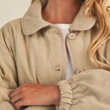 Close-up front detail of the wheat quilted cotton jacket showing texture and buttons