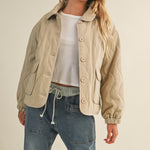 Styled front view of the wheat quilted jacket worn open for a casual look