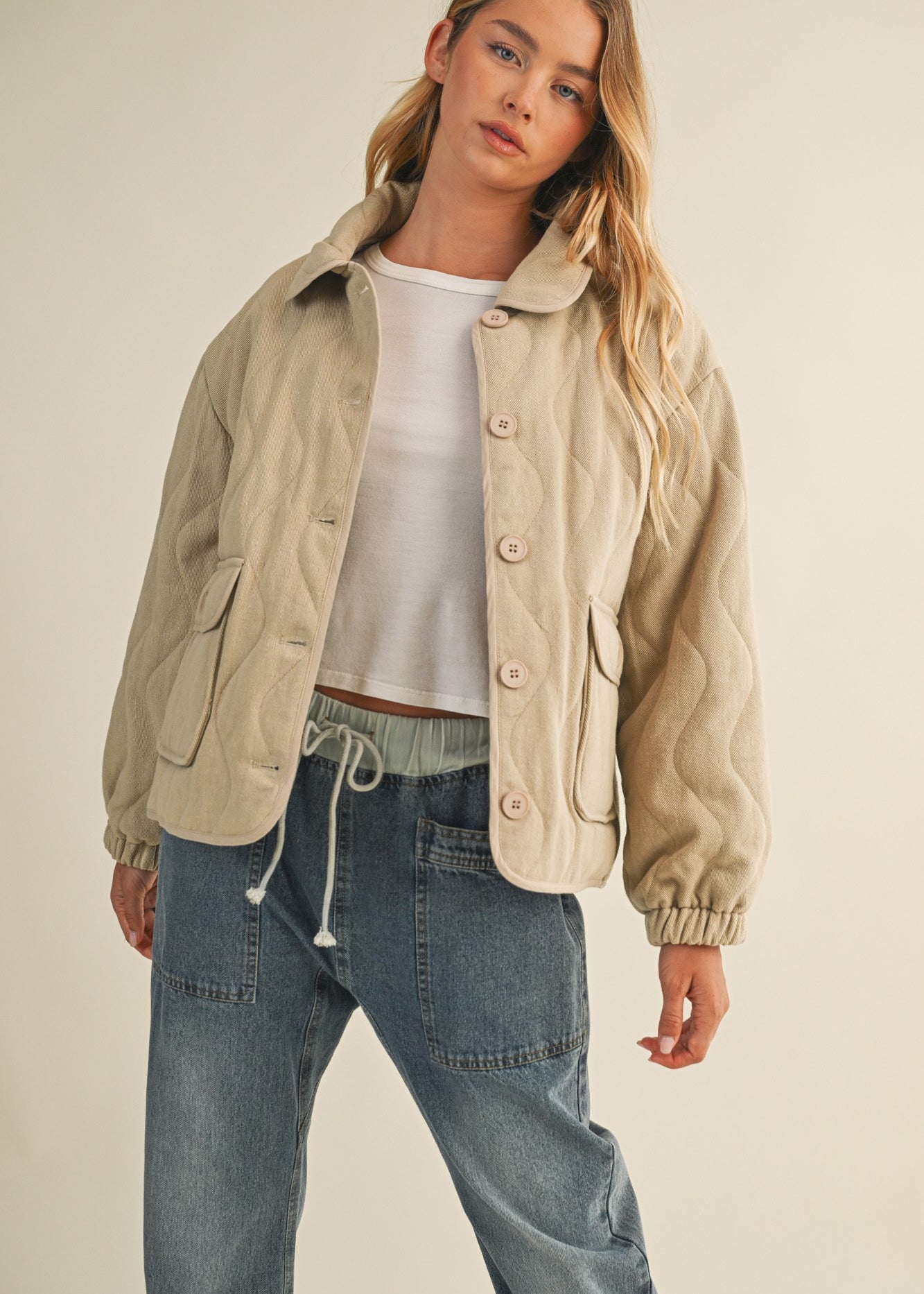 Styled front view of the wheat quilted jacket worn open for a casual look
