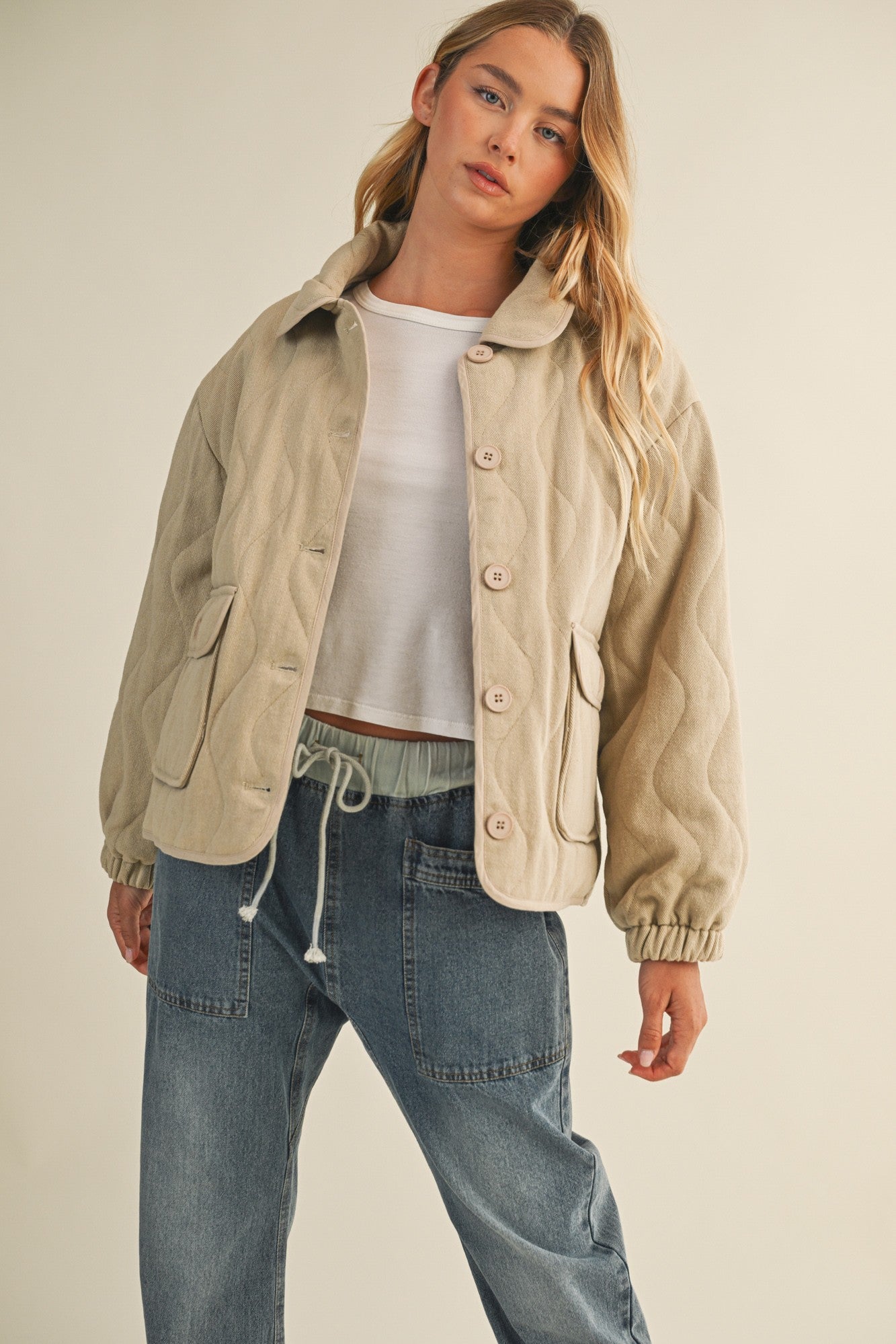 Styled front view of the wheat quilted jacket worn open for a casual look