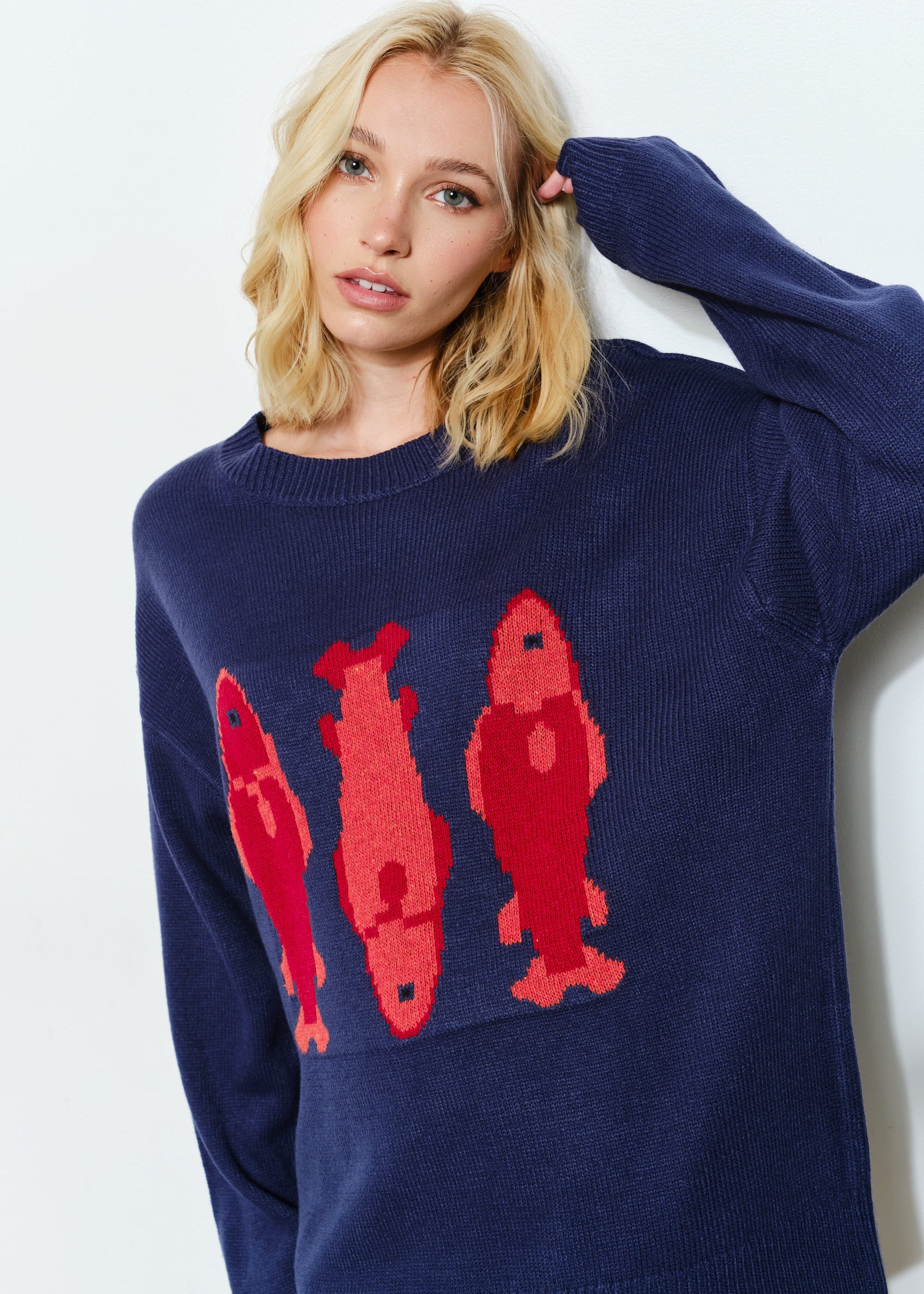 Woman is wearing  the Marina Fish Knit Sweater in navy — cozy and cute oversized fit sweater. 
