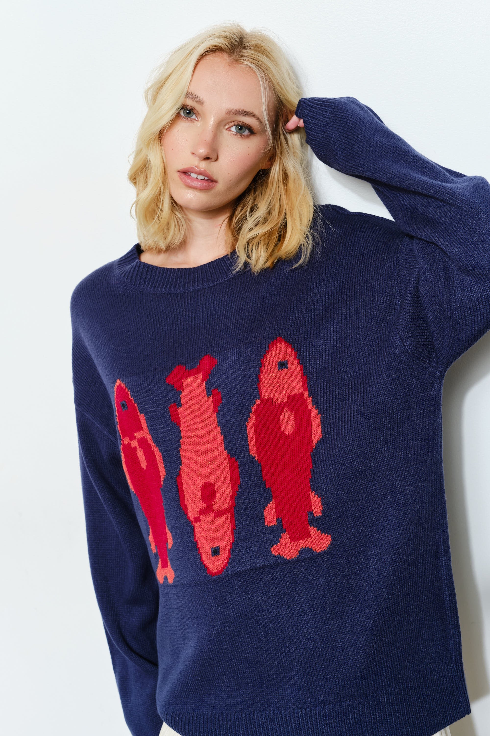 Woman is wearing  the Marina Fish Knit Sweater in navy — cozy and cute oversized fit sweater. 