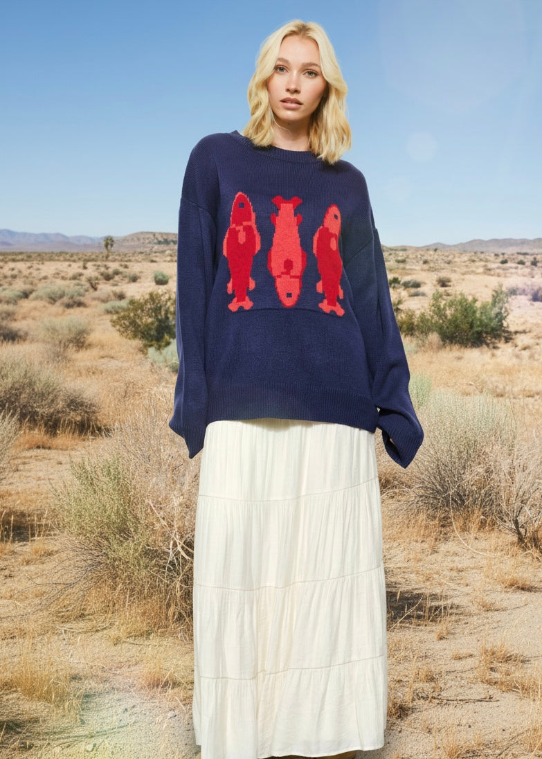 Marina Fish Knit Sweater in navy styled casually — soft chunky knit with playful red fish sardine pattern.