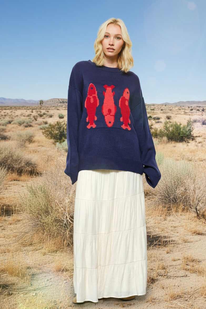 Marina Fish Knit Sweater in navy styled casually — soft chunky knit with playful red fish sardine pattern.