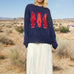Marina Fish Knit Sweater in navy styled casually — soft chunky knit with playful red fish sardine pattern.