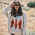 Woman wearing the Marina Fish Knit Sweater in sand — chunky oversized knit with playful red fish sardine motif