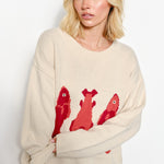 Model is posing - wearing fish embroidering sweater - beige color