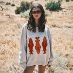 Woman wearing the Marina Fish Knit Sweater in sand outdoors — cozy and cute outfit