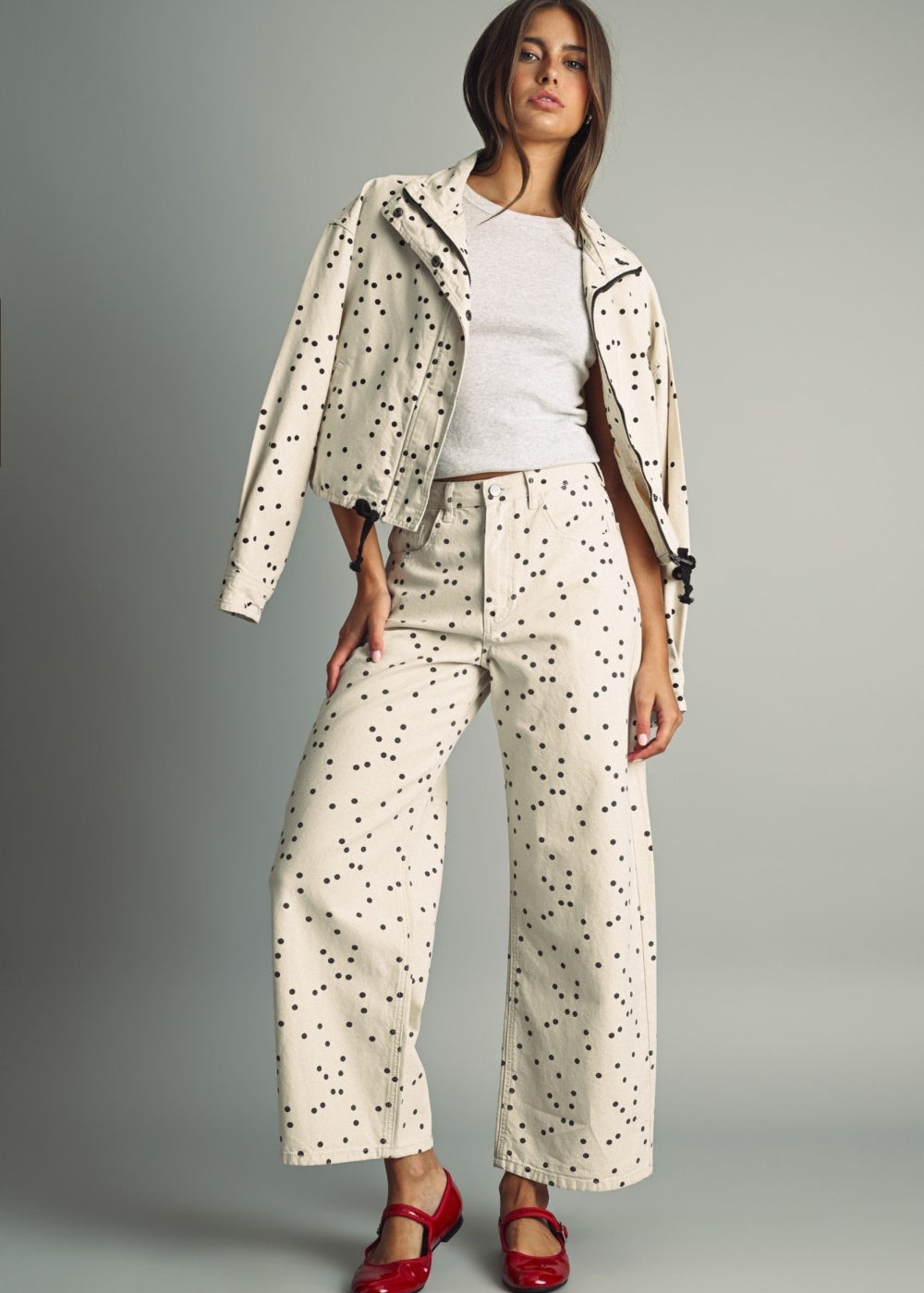 Model wearing MIOU MUSE ecru and black polka dot jacket with matching barrel jeans and red flats