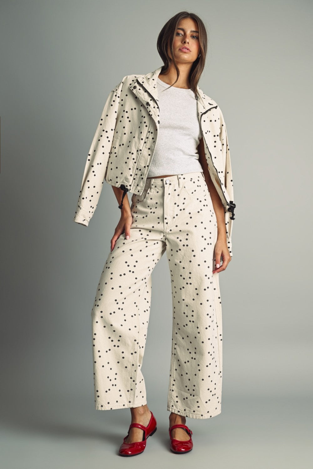 Model wearing MIOU MUSE ecru and black polka dot jacket with matching barrel jeans and red flats