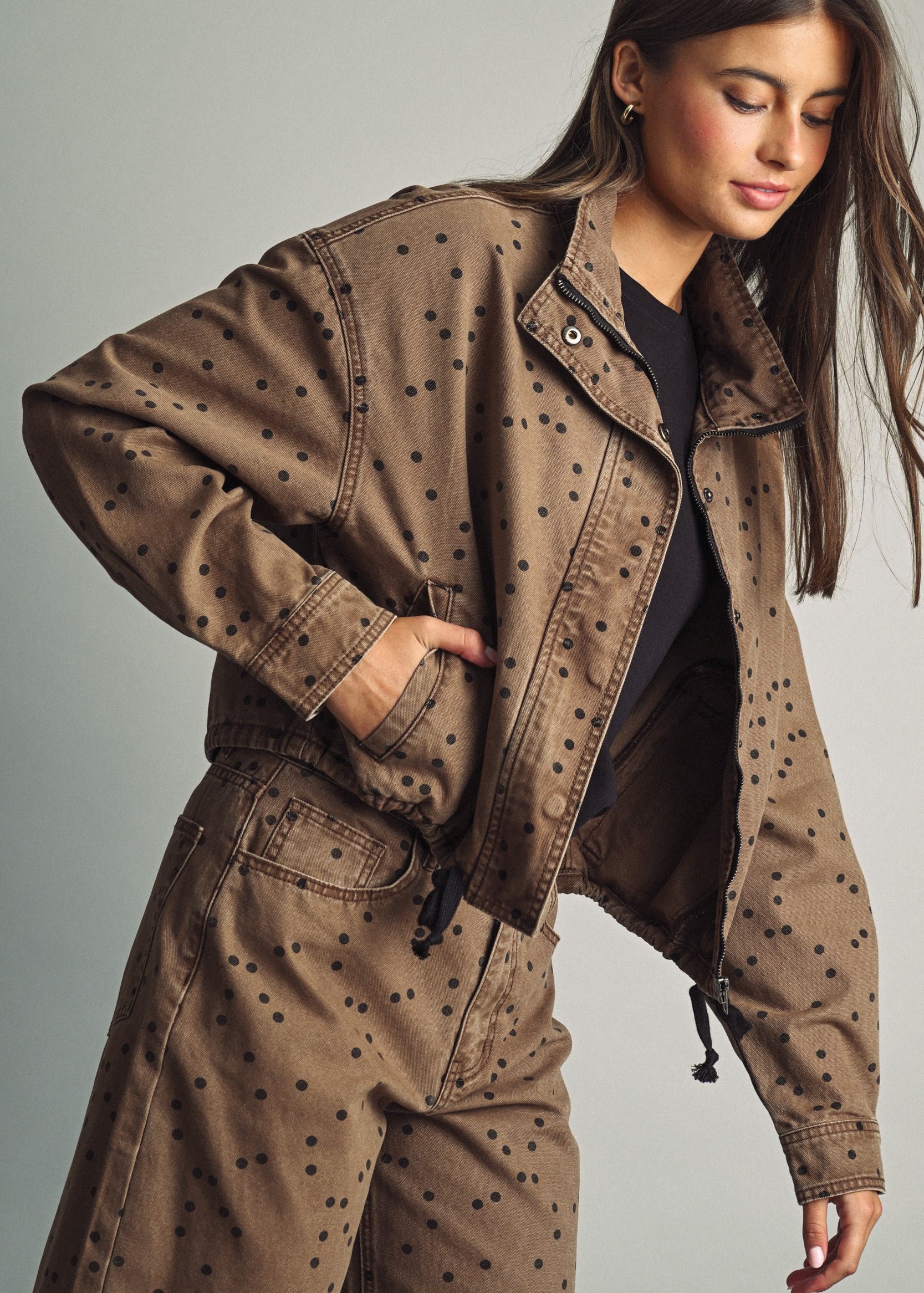 Front view of model wearing Miou Muse cocoa-brown jacket with black polka dots and a funnel neck