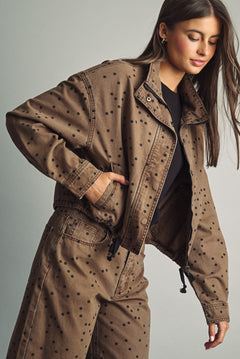 Front view of model wearing Miou Muse cocoa-brown jacket with black polka dots and a funnel neck