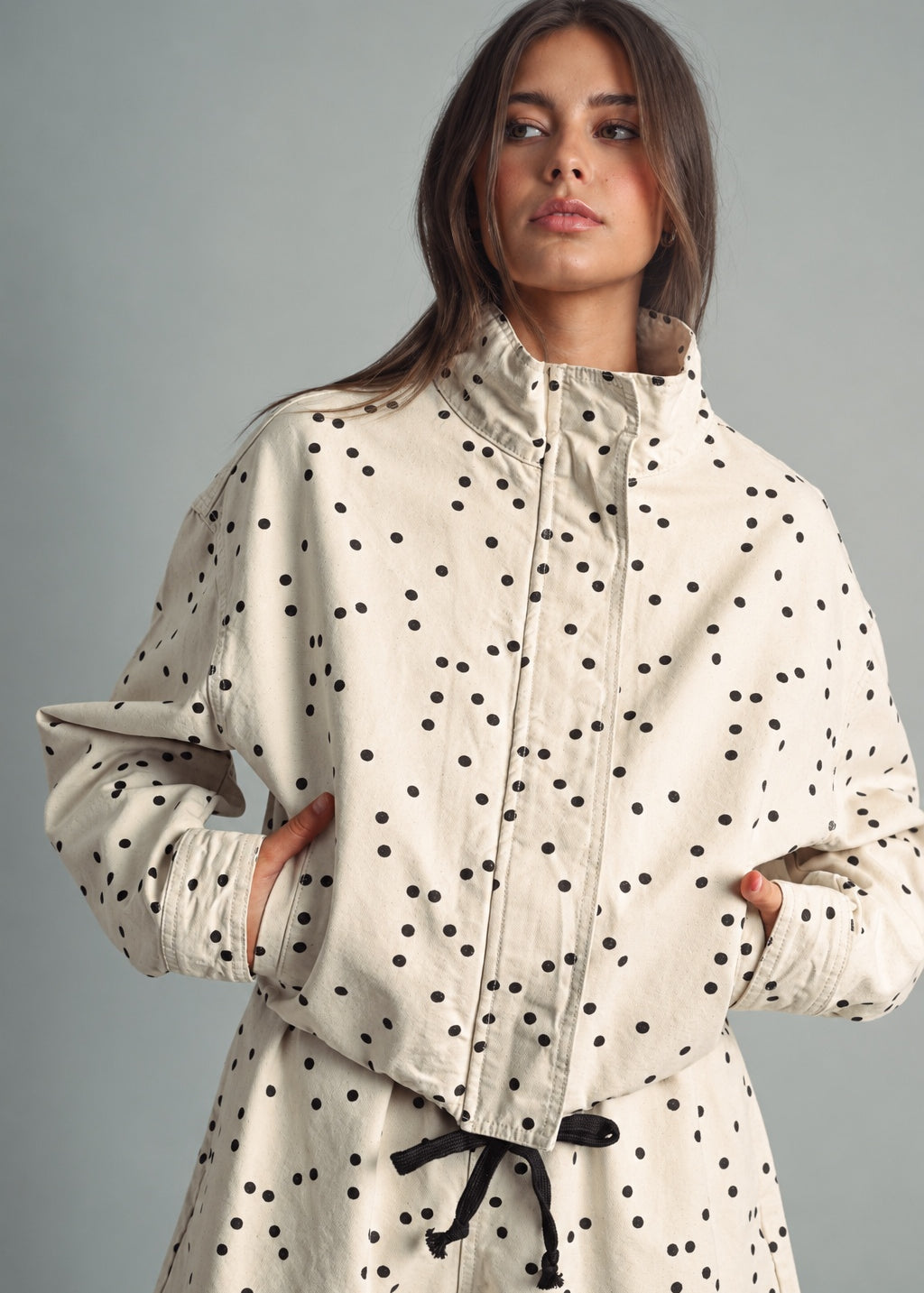 Front view of MIOU MUSE ecru jacket with black polka dots, a funnel neck, and a cropped boxy fit