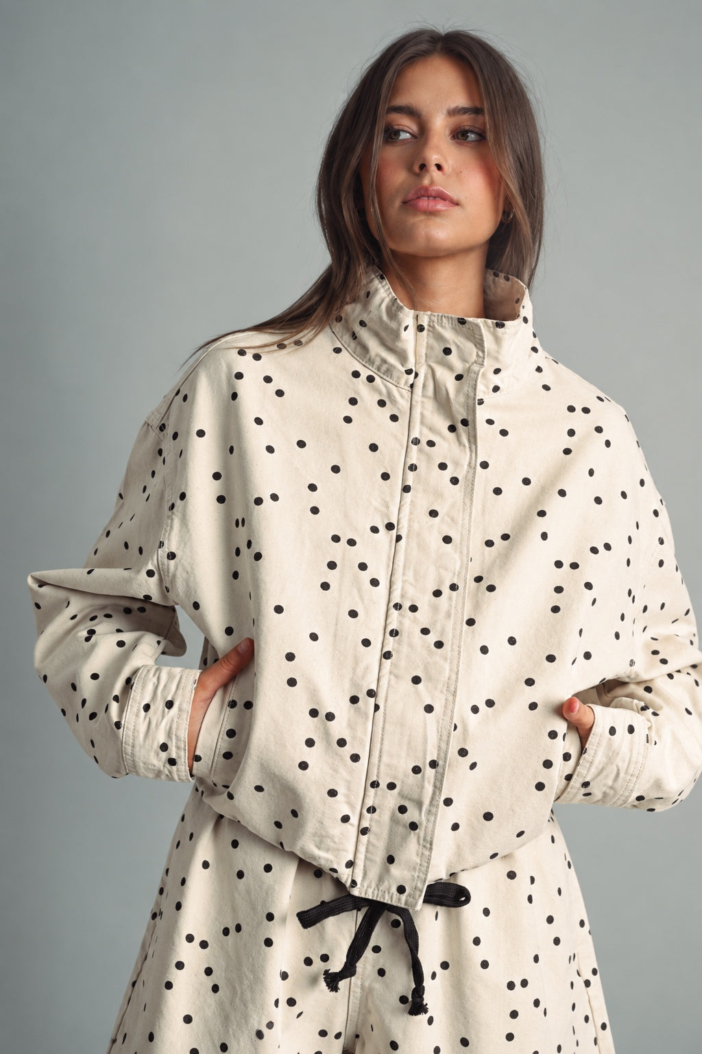 Front view of MIOU MUSE ecru jacket with black polka dots, a funnel neck, and a cropped boxy fit