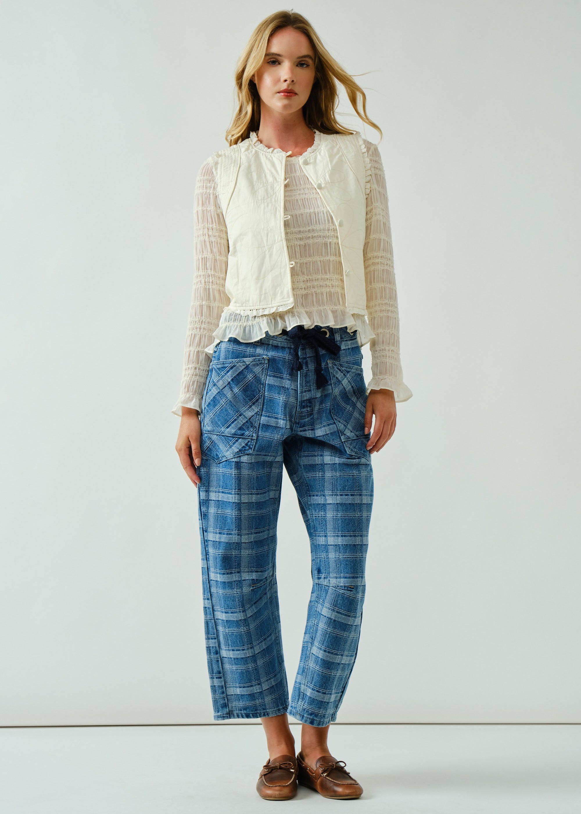 Front portrait of model wearing the Moxie Barrel Eyelet Jeans in blue plaid